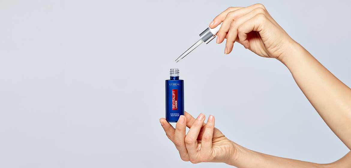 Nahaufnahme von zwei Händen die das L'Oréal Paris Revitalift Laser Serum halten